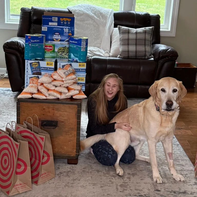 Ruby and Charlie sitting in front of all their food shelf supplies